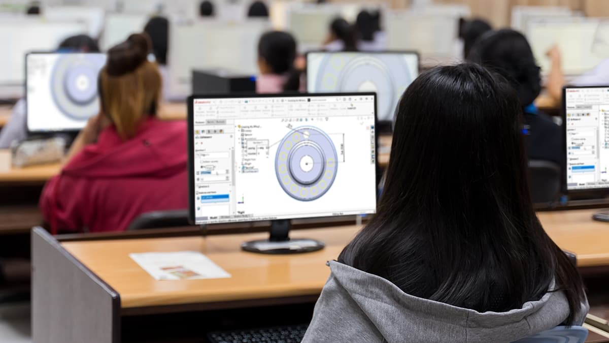 Students in a computer lab following a CAD lesson on desktop monitors.