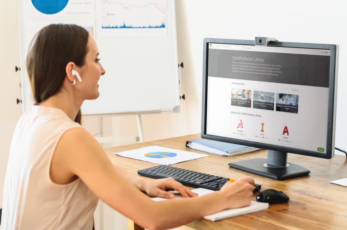 Learner attending a live virtual training session at a desktop computer.